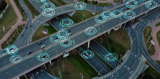 Vista aérea: Los vehículos eléctricos autónomos del futuro con elementos HUD se mueven a lo largo de una intersección de tráfico muy transitada. Concepto: Inteligencia Artificial, Car Scan, Rastreo GPS, Carreteras Inteligentes, IoT.